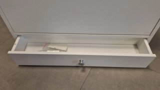 Mueble blanco con cajón.