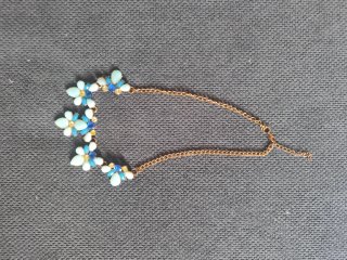 Gargantilla con flores azules y doradas