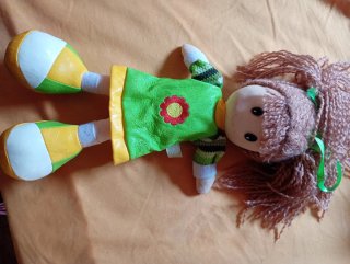 Muñeca de trapo con vestido verde y flor