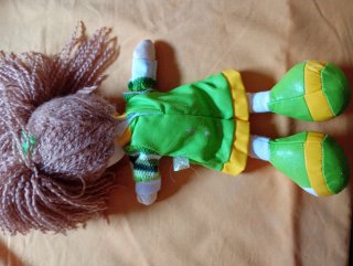 Muñeca de trapo con vestido verde y flor