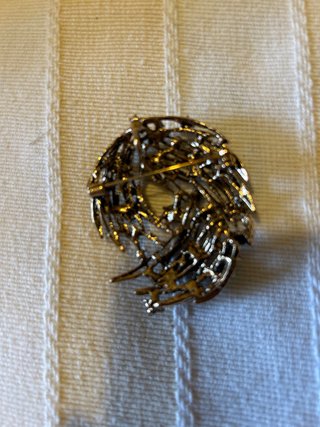 Broche dorado con piedras azules