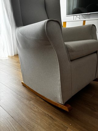 Sillón Mecedora Beige con base de madera clara.