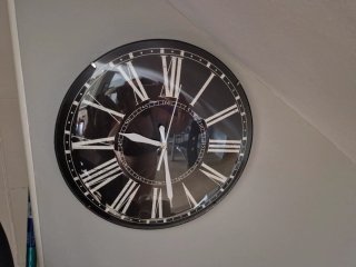 Reloj de pared negro con números romanos