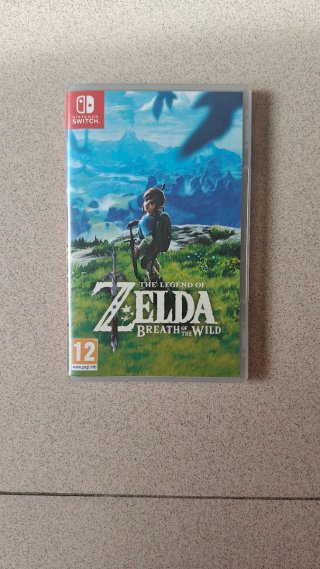 Nintendo Switch con Zelda y Mario, fundas y mando.