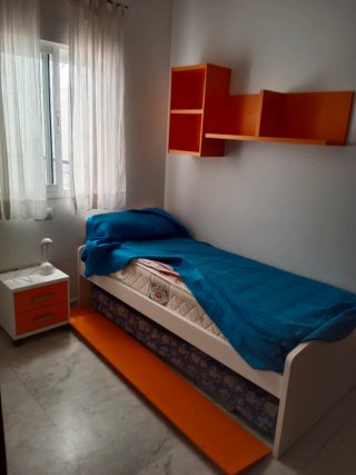 Habitación juvenil con cama y estantería