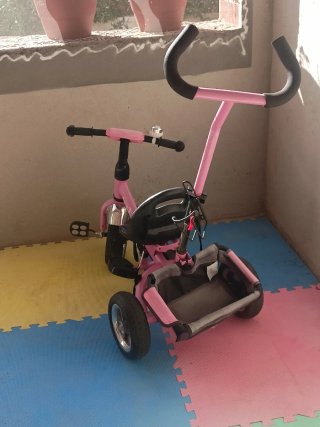 Triciclo infantil rosa con barra de empuje