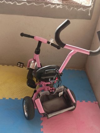 Triciclo infantil rosa con barra de empuje
