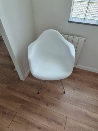 Silla tipo Eames blanca patas metálicas.