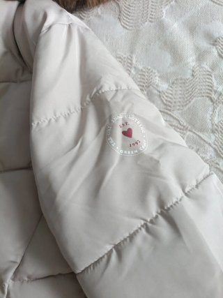Cazadora tipo plumas beige con capucha