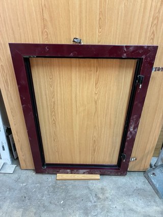 Ventana aluminio con marco burdeos.