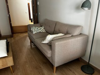 Sofá estilo nórdico de tela beige con cojines