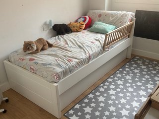 Cama nido blanca con barandilla de madera