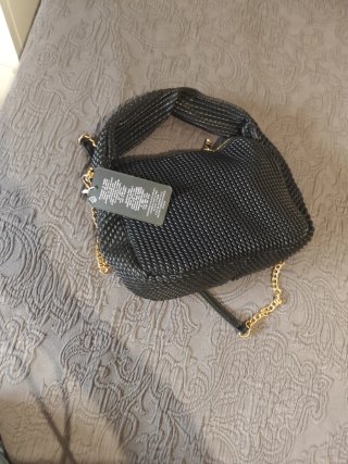 Bolso negro tejido con cadena dorada