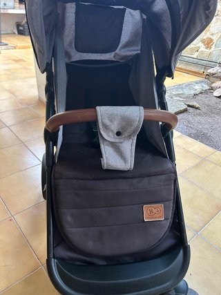 Carrito de bebé gris con detalles en piel