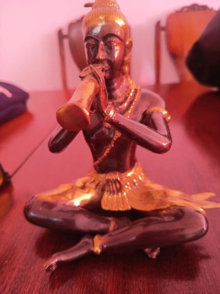 Figura Buda tocando flauta bronce y oro