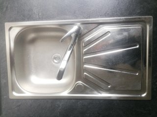 Muebles de cocina, fregadero y cocina de gas.