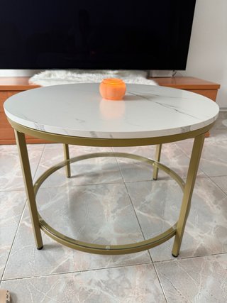 Mesa de centro redonda dorada y con efecto mármol.