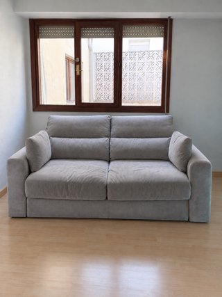 Sofá gris de tela con cojines