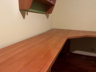Escritorio de madera en esquina con cajones.