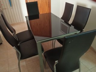 Mesa cristal y 6 sillas cuero negro