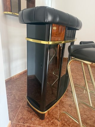 Barra de bar con taburetes y botellero
