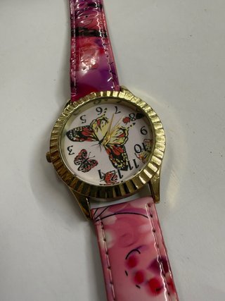 Reloj dorado con mariposas rosas