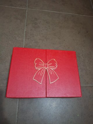 Caja de regalo roja con lazo dorado