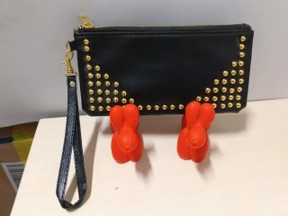 Cartera de mano negra con tachuelas doradas