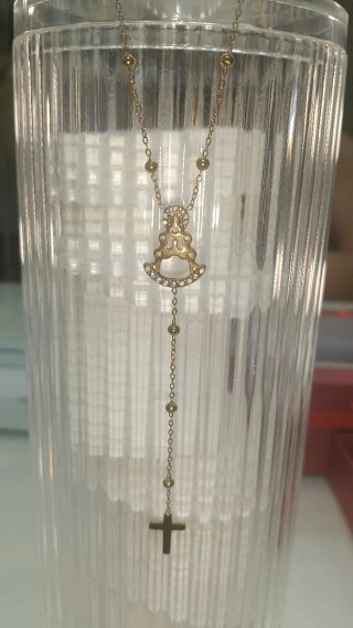 Collar dorado con cruz y figura religiosa