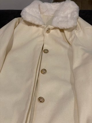 Abrigo blanco con cuello de pelo y botones dorados