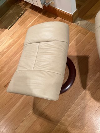 Sillón reclinable de piel beige con reposapiés