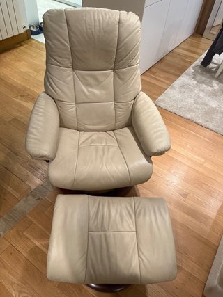 Sillón reclinable de piel beige con reposapiés