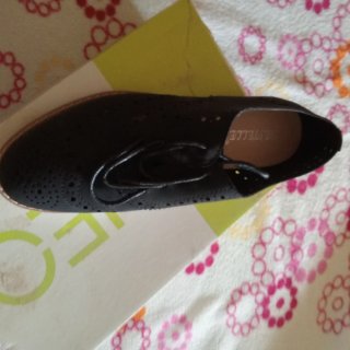 Zapato negro con cordones y perforaciones