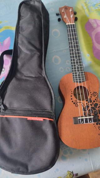 Ukelele marrón con funda negra