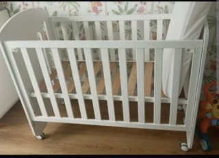 Cuna de bebé blanca con ruedas