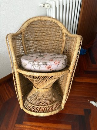 Sofá de mimbre con cojines florales