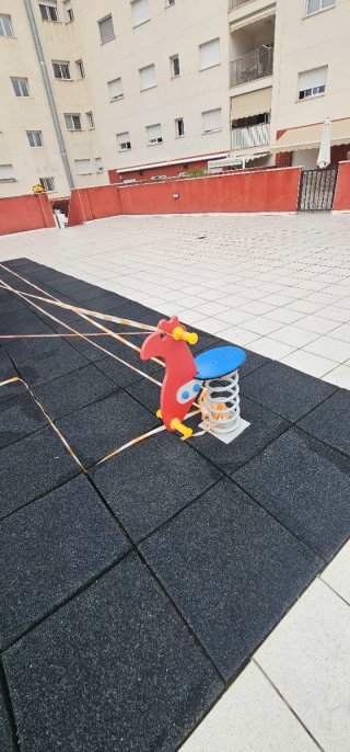 Parque infantil con columpio y tobogán y caballito