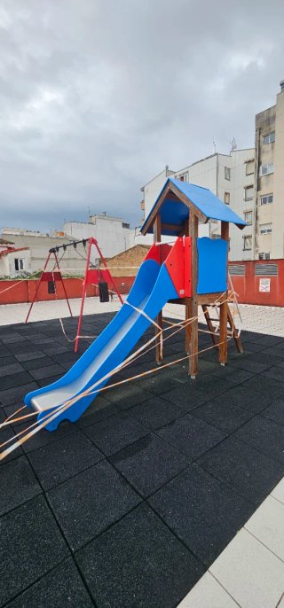 Parque infantil con columpio y tobogán y caballito