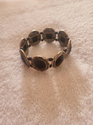 Pulsera elástica con piedras negras y detalles pla