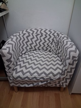 Sillón tela beige con funda gris y blanco.