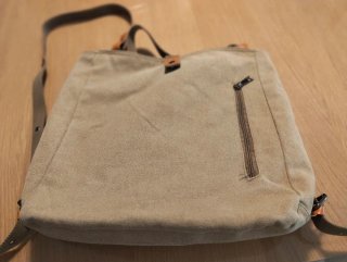 Mochila de tela beige con múltiples bolsillos