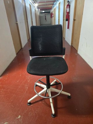 Silla de oficina con ruedas y base blanca.