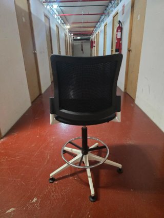Silla de oficina con ruedas y base blanca.
