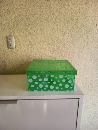 Caja de plástico verde con puntos blancos