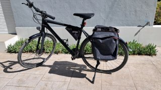 Bicicleta de trekking negra con alforja