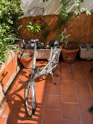 Bicicleta plegable plateada con portaequipajes