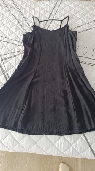 Vestido corto de color negro y tirantes finos.
