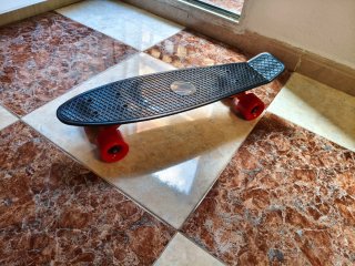 Monopatín negro con ruedas rojas
