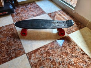 Monopatín negro con ruedas rojas