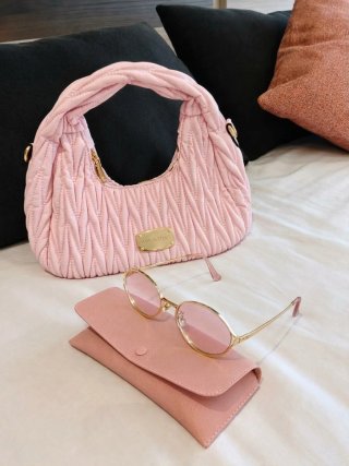 Bolso rosa y gafas de sol doradas